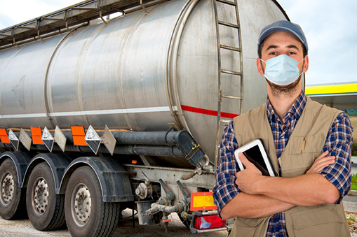 A man stands in front of a tanker-truck