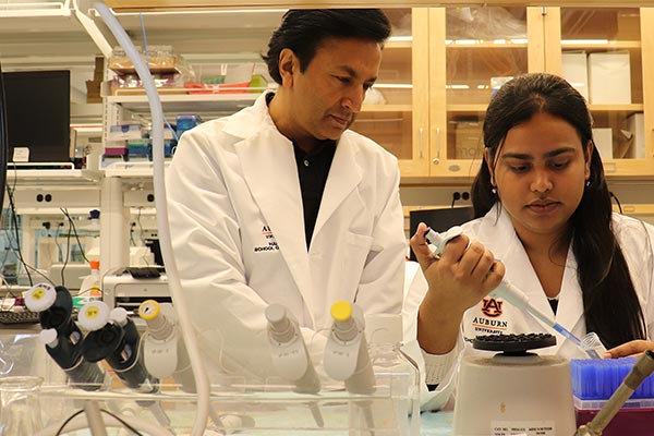 Amin in a lab with student.