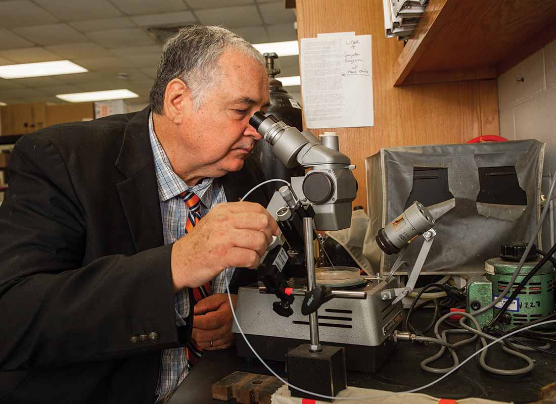 Dr. Rex Dunham looks into a microscope