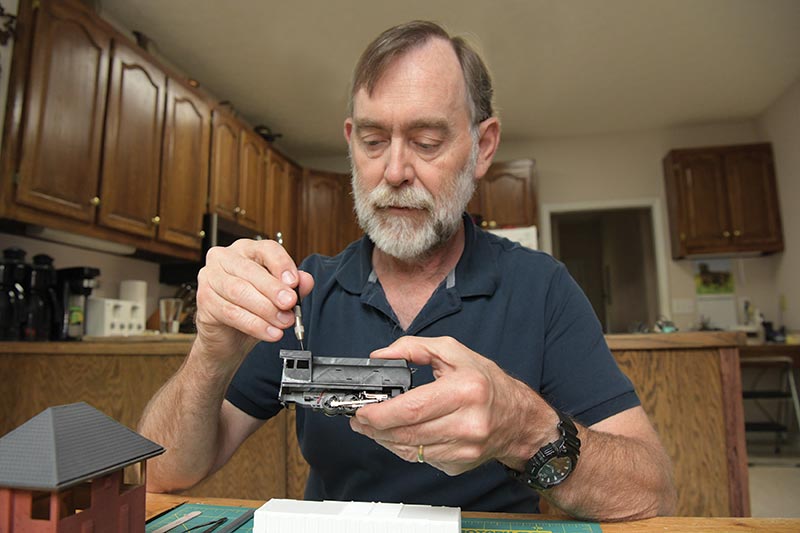 Dr. Bruce Smith works on a model train.