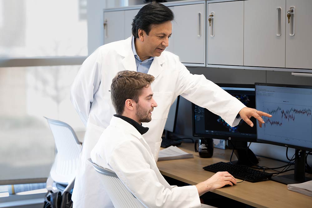 Two researchers looking at a computer monitor